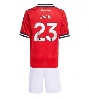 Lacne Dětský Futbalové dres Manchester United Luke Shaw #23 2025-26 Krátky Rukáv - Domáci (+ trenírky)